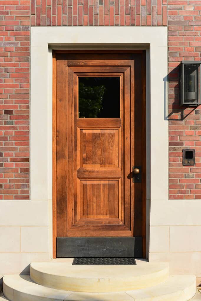 Holzhaustür mit zwei Stufen vorm Eingang