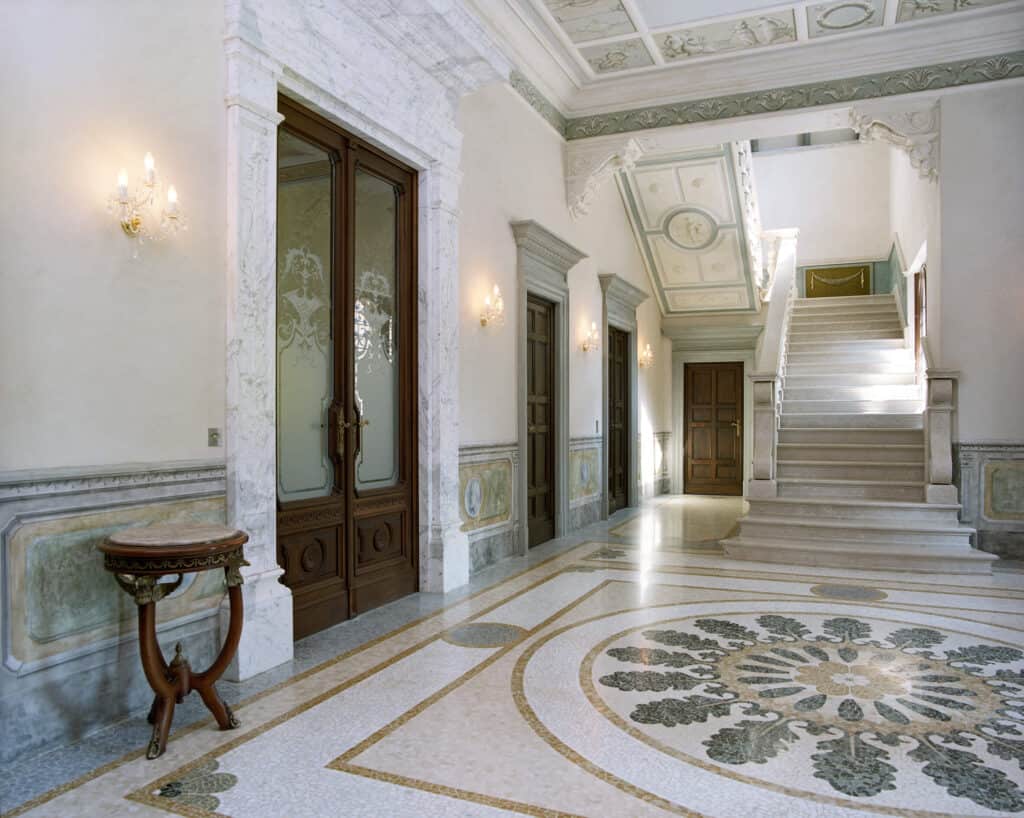 heller Eingangsbereich von der Villa Galimberti mit gemusterten Fliesen und Deckenbemalung